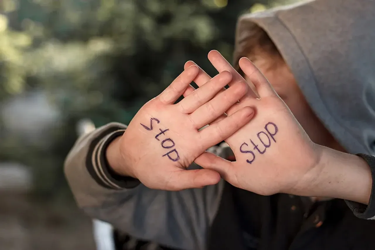 stop child abuse . Upset abused frightened little boy, stop hand gesture close up portrait with copy space.